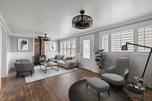 Living room with crown molding, dark hardwood flooring, and a wood stove