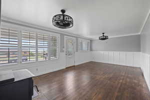 Entryway featuring ornamental molding and dark hardwood / wood-style floors