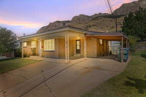 View of front of house featuring a yard, a carport, and a mountain view