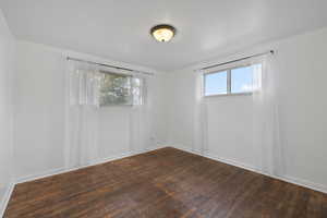 Bedroom room featuring light walls and dark hardwood flooring