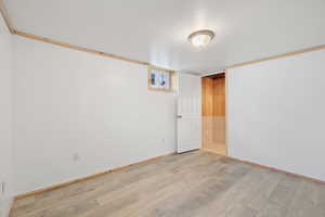 Spare bedroom featuring light LVP flooring and ornamental molding