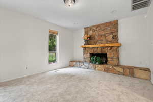 Unfurnished living room featuring a fireplace and carpet flooring