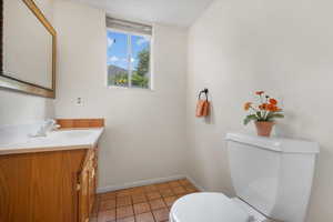 Bathroom featuring tile patterned flooring, toilet, and vanity