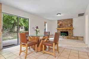 Carpeted dining room featuring a wealth of natural light and a fireplace