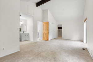 Interior space with a textured ceiling, high vaulted ceiling, beam ceiling, and sink