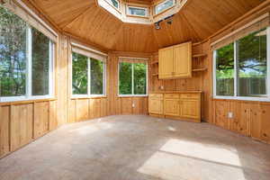 Unfurnished sunroom with wooden ceiling and vaulted ceiling