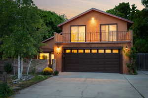 Front facade featuring a balcony and a garage