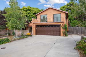 View of front property with a garage and a balcony