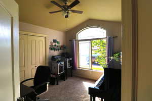 Office area featuring ceiling fan, carpet floors, and vaulted ceiling