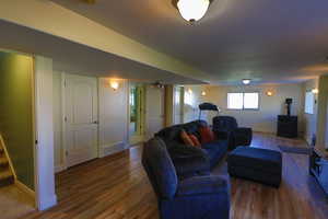 Living room with wood-type flooring Projector and Screen Included