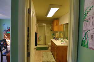 Bathroom with tile patterned floors, a shower with shower door, vanity, and toilet