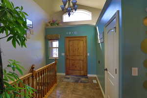 Foyer featuring lofted ceiling and an inviting chandelier