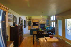 Dining space featuring light wood-type flooring and a brick fireplace