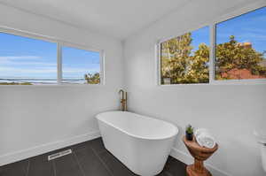 Bathroom with a tub and tile patterned floors