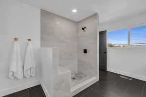 Bathroom featuring tiled shower and tile patterned floors