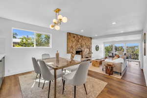 Dining space featuring a fireplace, hardwood / wood-style floors, and an inviting chandelier