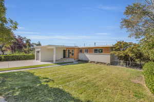 View of front of house with a garage and a front lawn