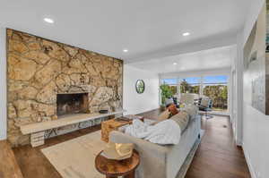 Living room with dark hardwood / wood-style floors and a fireplace