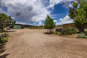 View of yard with a rural view and a storage unit