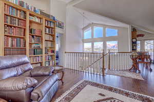 Living area featuring high vaulted ceiling, a healthy amount of sunlight, and hardwood / wood-style floors