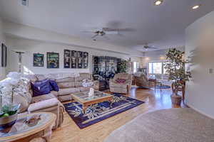 Living room with ceiling fan and light wood-type flooring