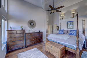 Bedroom featuring dark hardwood / wood-style flooring, a high ceiling, and ceiling fan