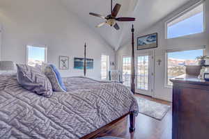 Bedroom with light wood-type flooring, high vaulted ceiling, access to outside, and ceiling fan