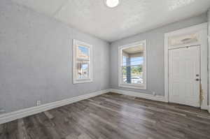 Empty room featuring dark hardwood / wood-style flooring and a textured ceiling