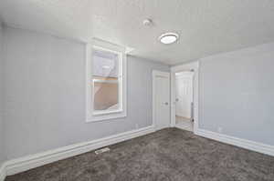 Spare room featuring light carpet and a textured ceiling