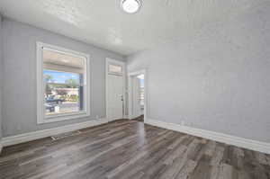 Entryway with lofted ceiling, dark hardwood / wood-style flooring, and a textured ceiling