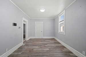 Empty room featuring ornamental molding and hardwood / wood-style floors