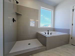 Bathroom featuring plenty of natural light and independent shower and bath