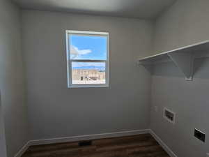 Washroom with hookup for a washing machine, hookup for an electric dryer, and dark hardwood / wood-style flooring