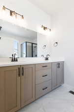 Bathroom with vanity and a shower with door