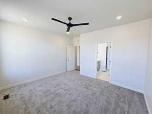 Unfurnished bedroom featuring ensuite bath, light colored carpet, and ceiling fan