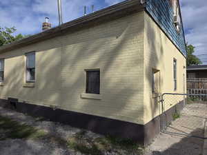 SE house corner. Back door to right, driveway to left.