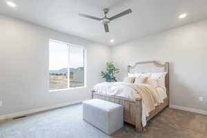 Bedroom featuring ceiling fan and dark colored carpet