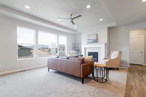 Living room with light hardwood / wood-style floors and ceiling fan