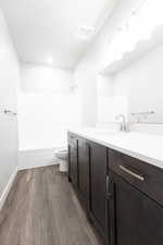 Full bathroom with vanity, hardwood / wood-style flooring, toilet, and shower / bathtub combination