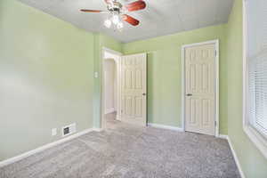 Unfurnished bedroom with carpet flooring and ceiling fan