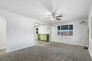 Unfurnished living room featuring ceiling fan and light colored carpet