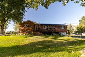 Rear view of house featuring a lawn and a garage