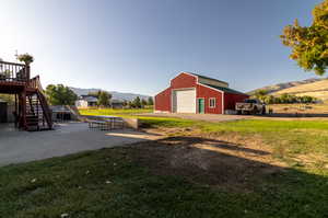 View of yard with an outbuilding, a deck with mountain view, and a garage