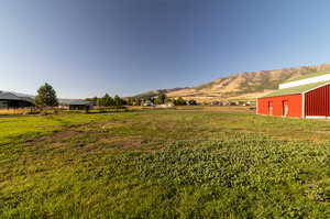 View of yard with an outdoor structure, a rural view, and a mountain view