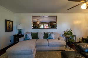 Main Living room with crown molding, dark wood-type flooring, and ceiling fan