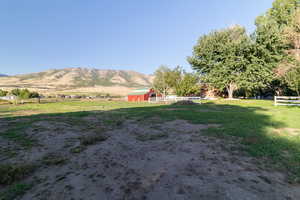 View of yard featuring a mountain view, an outdoor structure, and a rural view