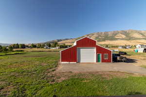 View of Barn featuring a garage door with opener,  a rural view, and a mountain view