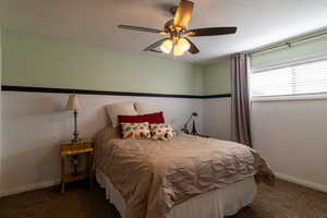 Carpeted bedroom featuring ceiling fan