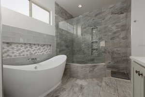 Bathroom with vanity, plus walk in shower, and decorative backsplash