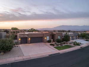 Pueblo-style house featuring a mountain view and a garage